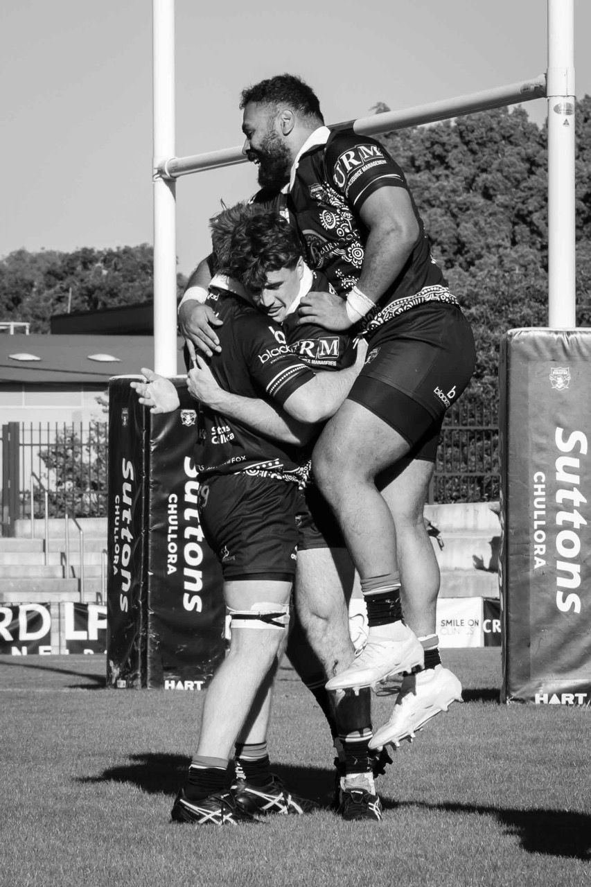 A player leaps into a teammate’s arms after a try
