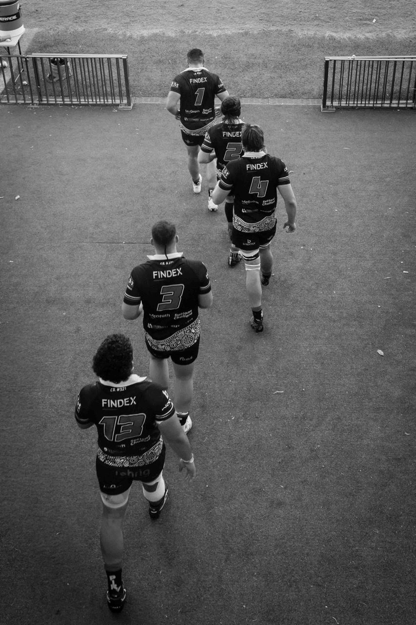 Players walk out onto the field in single file