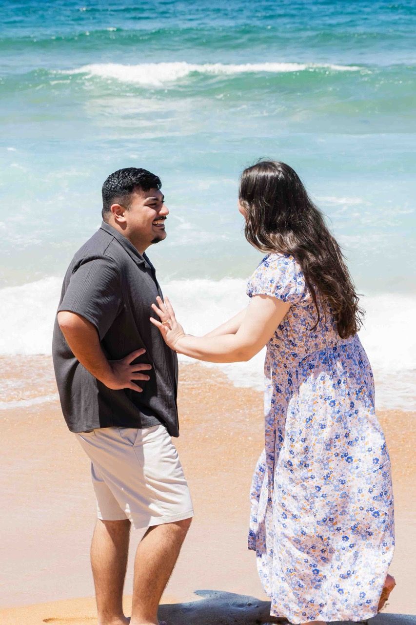 The couple laugh together at the water’s edge