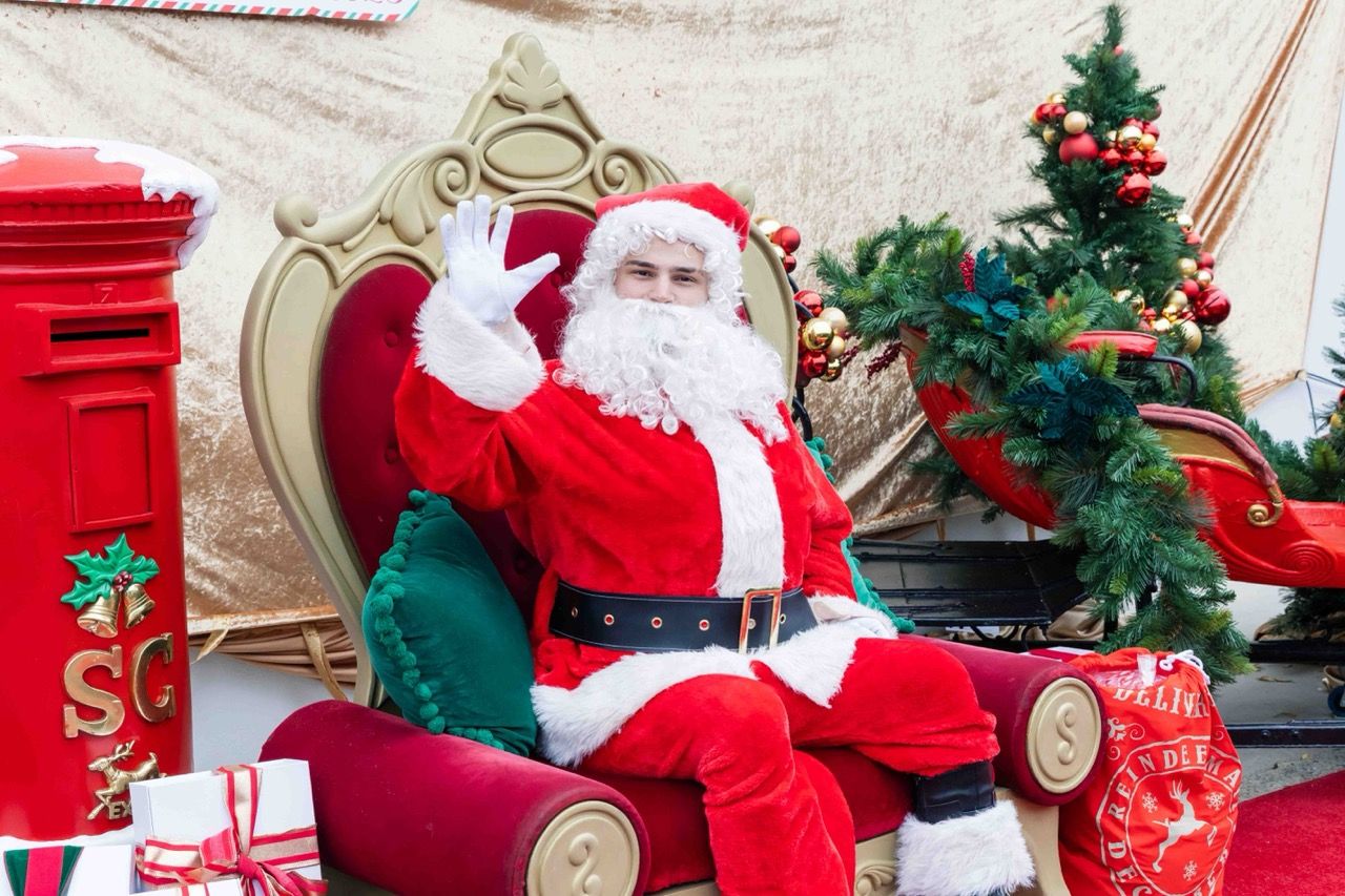 Santa waves from his sleigh throne