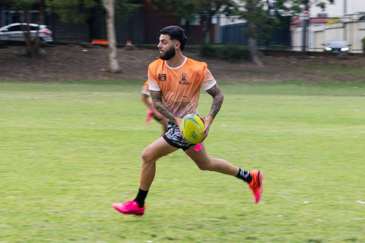 A player sprints with the ball at a community sports day