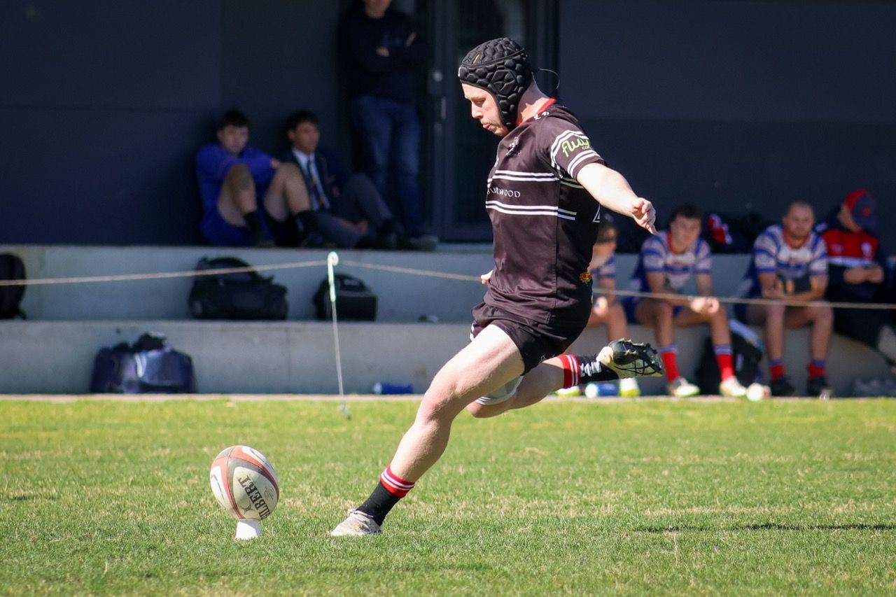 A Colts player kicks for goal in front of the stand