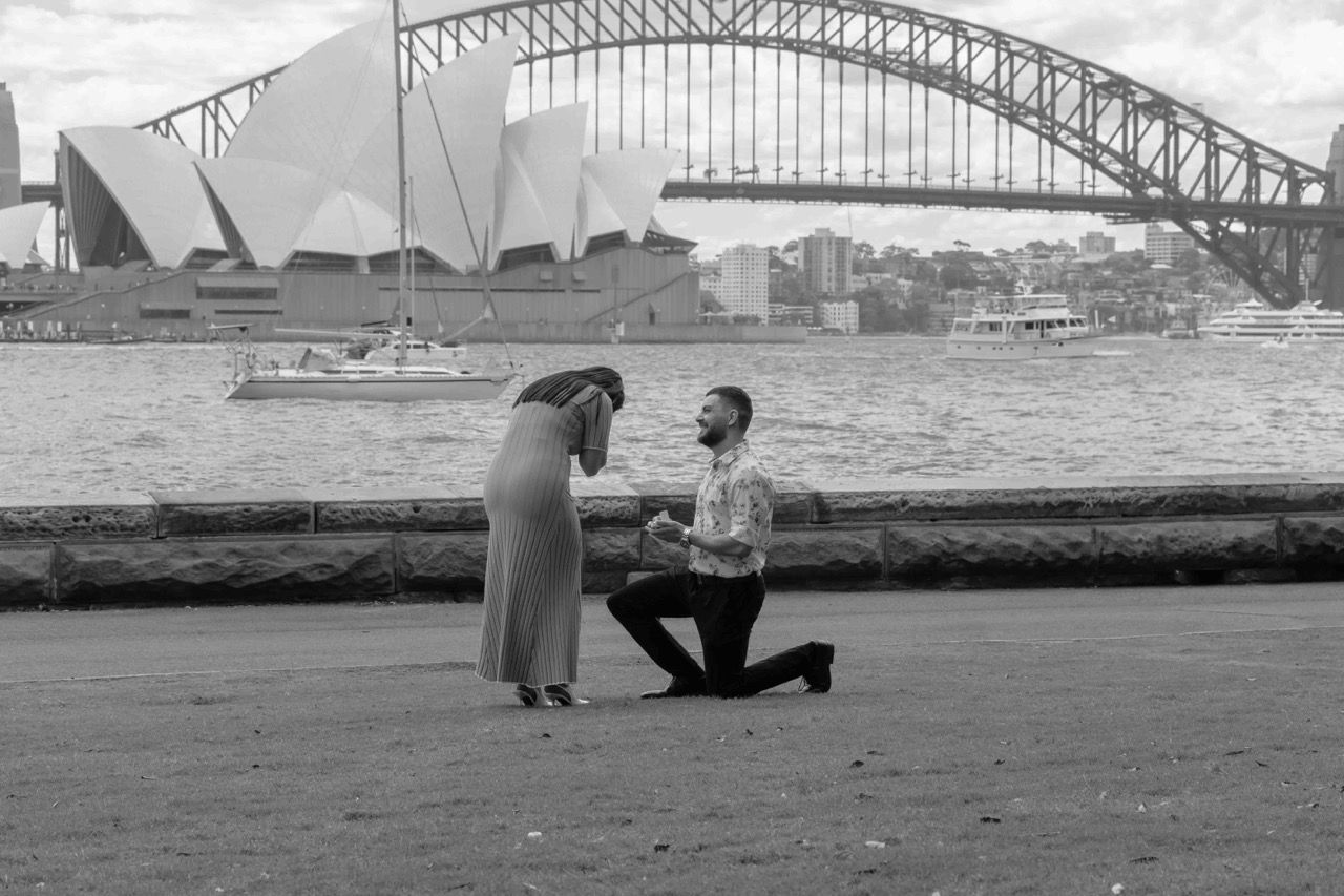 He kneels to propose in front of the Opera House
