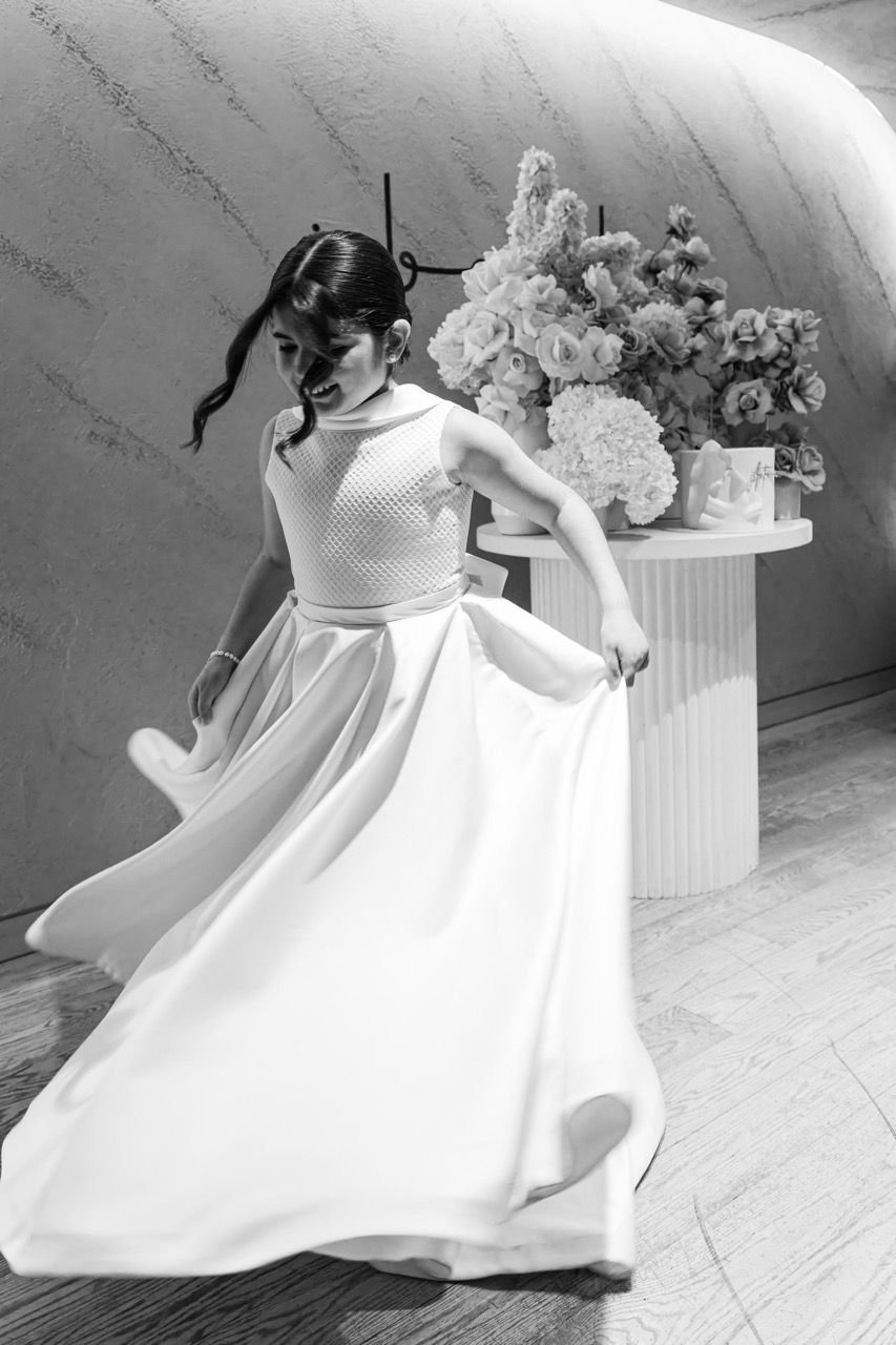 A girl twirls in a full white dress