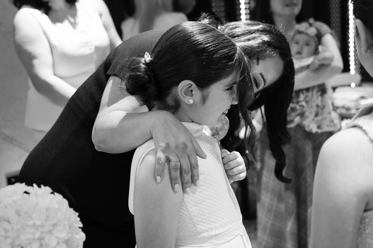 A girl is hugged by family at her celebration