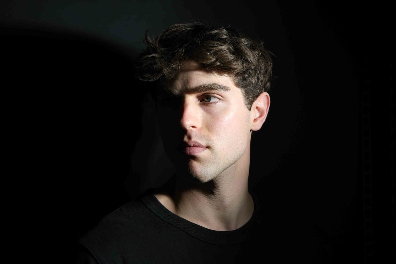 A studio portrait looking away into soft shadow